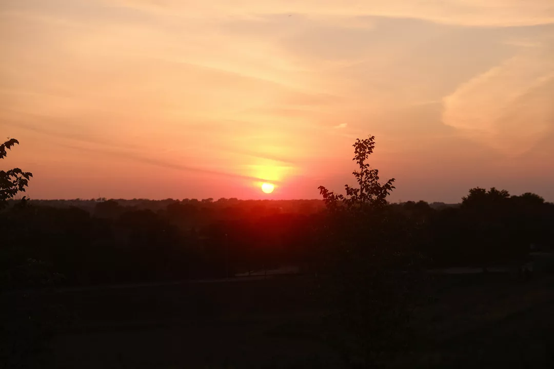 Photo of the sun setting in a smokey sky
